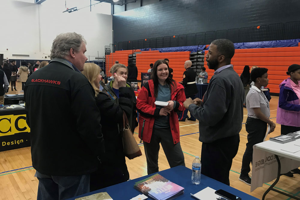A volunteer speaking with a prospective student family